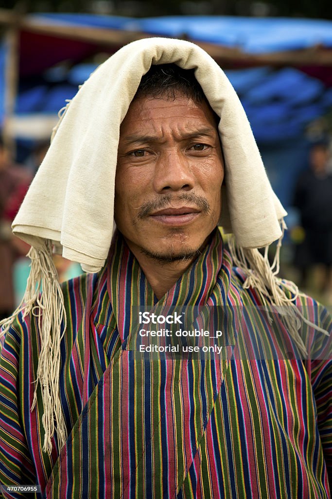 traditional Bhutanese wear Punakha, Bhutan - september 23rd, 2012 :  man wearing a traditional scarf on his head against the hot sun. At all festivals men are required to carry this scarf. Bhutan Stock Photo