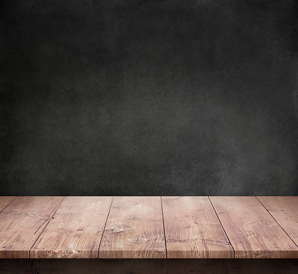 istock A plank wood table in front of a dark concrete background 470708064