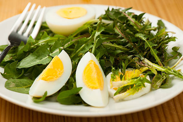 istock Fresh spring green dandelion salad with eggs on a plate 470710648
