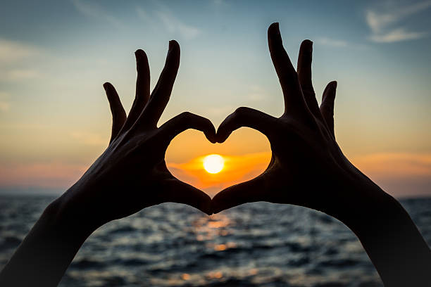 istock heart shape hand silhouette with sunset 470711162
