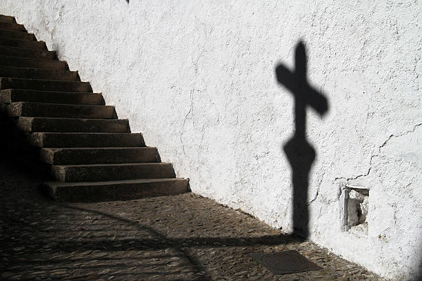 Shadow of a cross shown on the city walls of Ronda, Spain.
