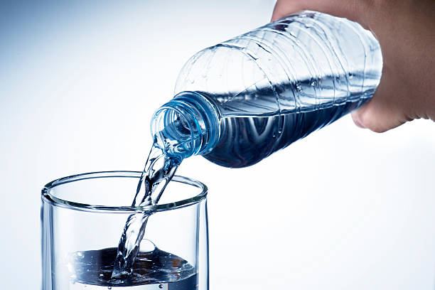 Hand holding bottle water and pouring stock photo