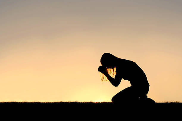 christian mujer sentándos'en la oración silueta - praying girl fotografías e imágenes de stock