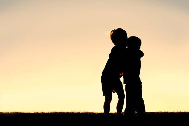 istock Silhouette of Two Young Children Hugging at Sunset 470724054
