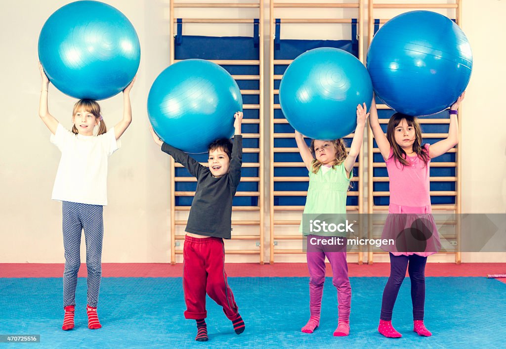 Children at physical education class Children at physical education class, playing with fitness balls Child Stock Photo