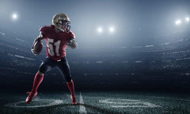 American football in action A male american football player makes a dramatic play. The stadium is blurred behind him.  The player is wearing generic unbranded american football uniform. The stadium is 3D rendered. football player stock pictures, royalty-free photos & images