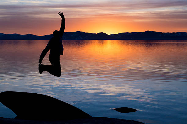 Silhouette Jumping at Sunset on Tahoe stock photo