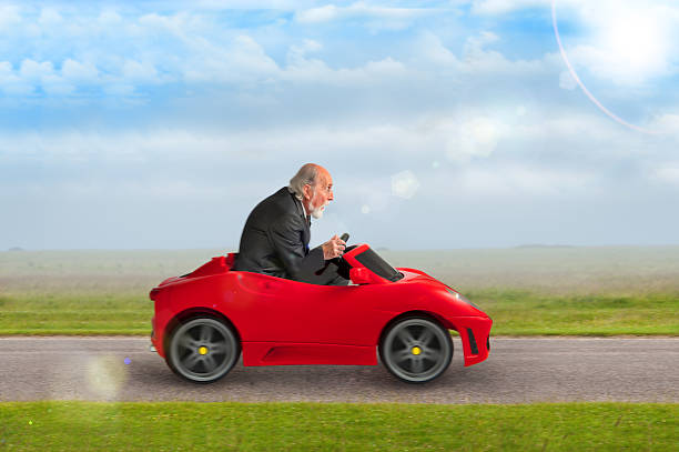 istock senior man driving a toy racing car 470730950