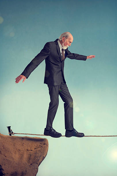 istock senior man walking a tightrope 470731504