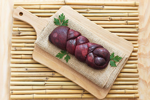Braided Mozzarella marinated in red wine on sackcloth, wooden bo Treccia - braided Mozzarella cheese marinated in red wine on sackcloth on wooden board on bamboo. Selective focus bamboo twist stock pictures, royalty-free photos & images
