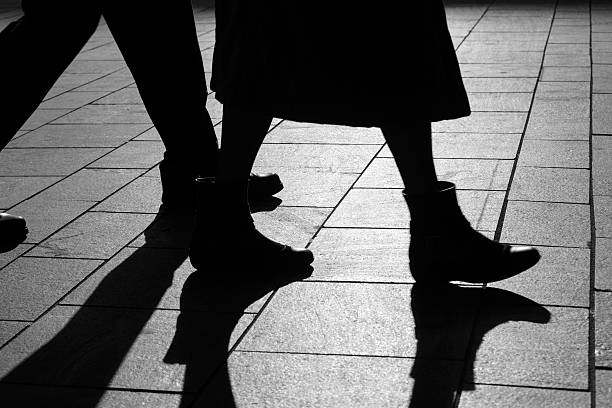 istock sun casting shadow over two people walking on the street 470732558