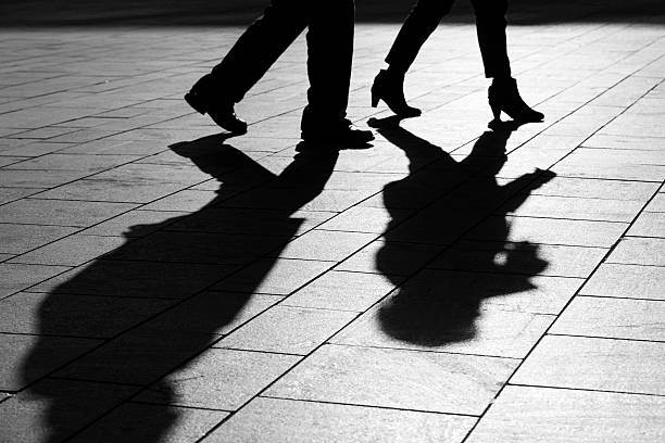 istock sun casting shadow over a couple walking on the street 470732572