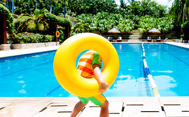 garçon avec tube flottant - swimming pool child swimming buoy photos et images de collection