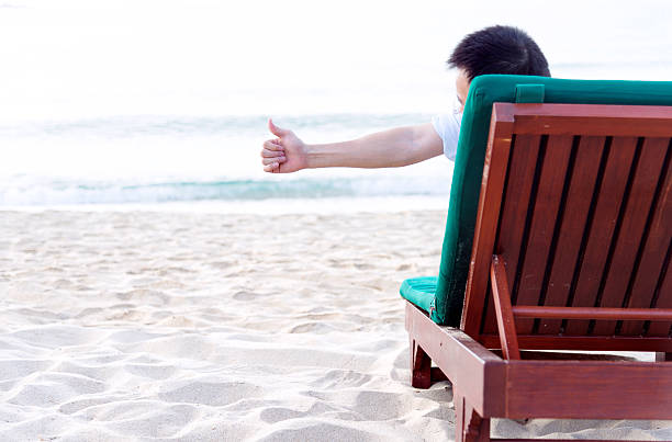 istock man relaxing on beach 470735750