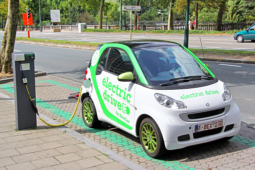 Brussels, Belgium - August 9, 2014: Modern electric minicar Smart Fortwo charging at the city street.