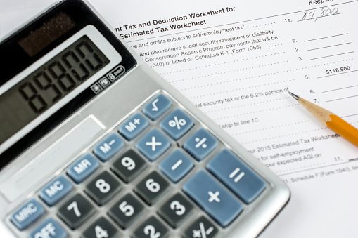 Close-up of a United States tax deuction worksheet.  Shown with a pencil and calculator.