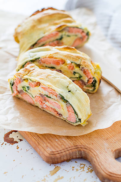 istock Strudel pie with salmon and spinach, served on wood board 470743386