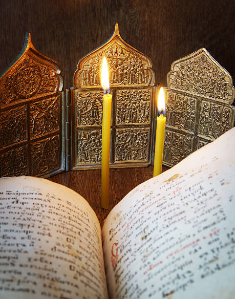 istock Christian still life with open ancient book and burning candles 470744236