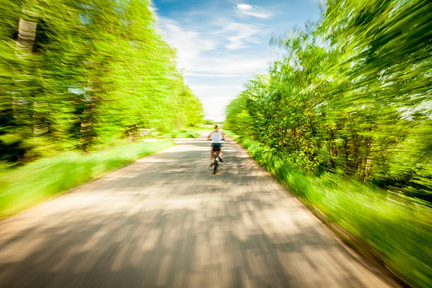 istock Blurred motion of bicycling woman 470744406