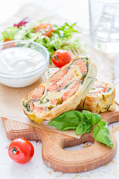 istock Strudel pie with salmon and spinach, served on wood board 470744496