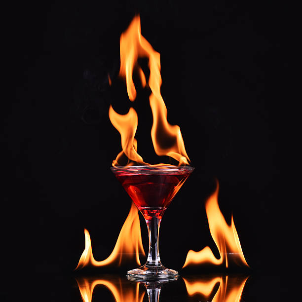 istock Red alcohol cocktail in glass with fire 470745136