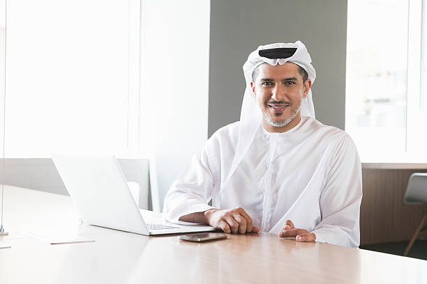 Confident Arab businessman at conference table in office stock photo