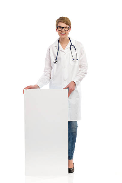 istock Smiling female doctor stands behind banner. 470746287