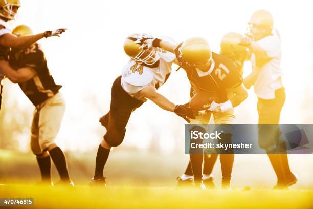 American Football Players In Action At Sunset Stock Photo - Download Image Now - American Football Player, Activity, Adult