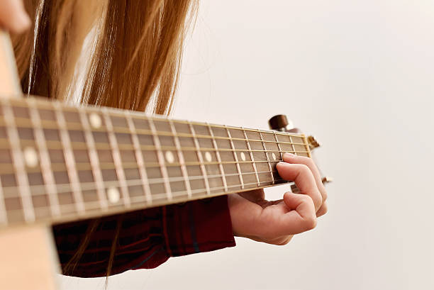 istock woman's hands playing acoustic guitar, close up 470747644