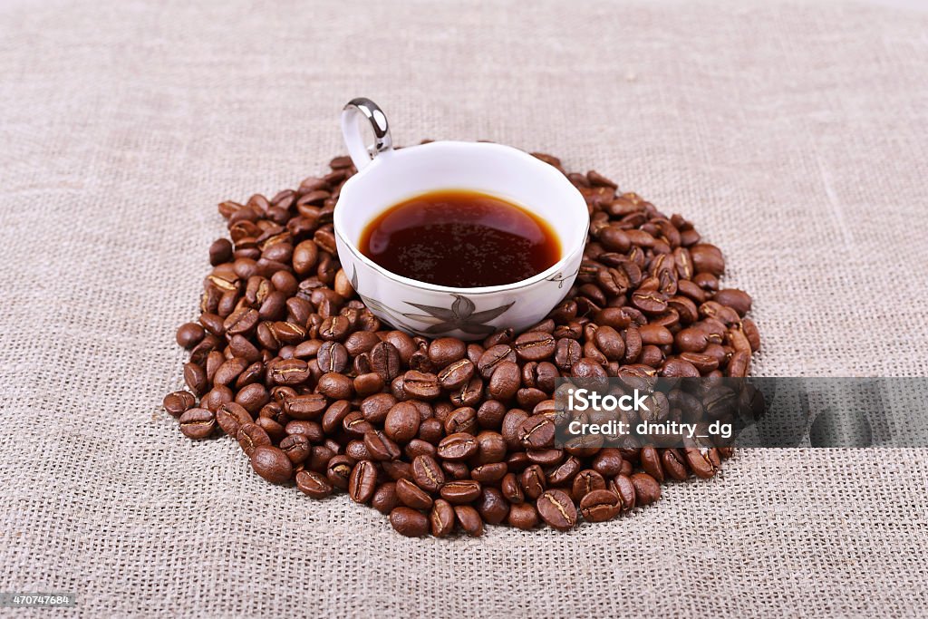 Cup of coffee with coffee beans on linen texture table 2015 Stock Photo
