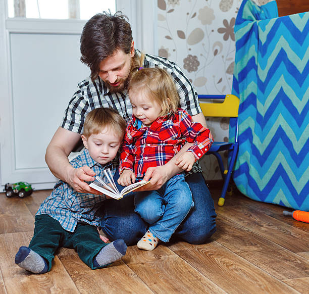 istock Father reading a book to children 470748040