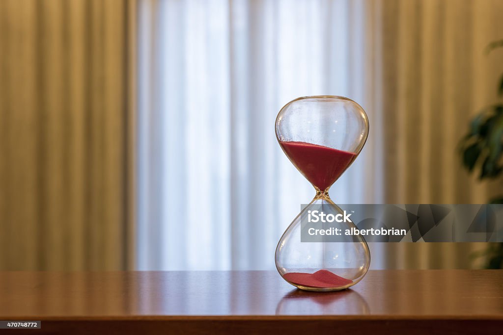 Modern Hourglass Modern Hourglass - sand trickling through the bulbs of a crystal sand glass. 2015 Stock Photo