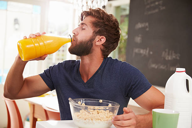 istock Young Man Eating Breakfast And Drinking Orange Juice 470750798