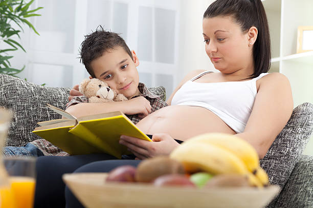 istock pregnant mother reading a book child 470751639