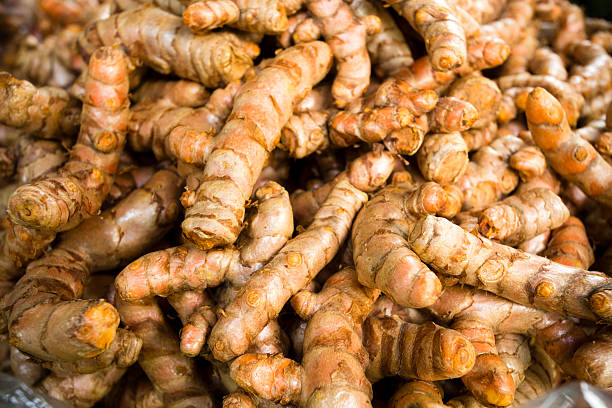 Fresh ripe turmeric root in a market in Thailand. Turmeric is the spice that gives curry its yellow color.