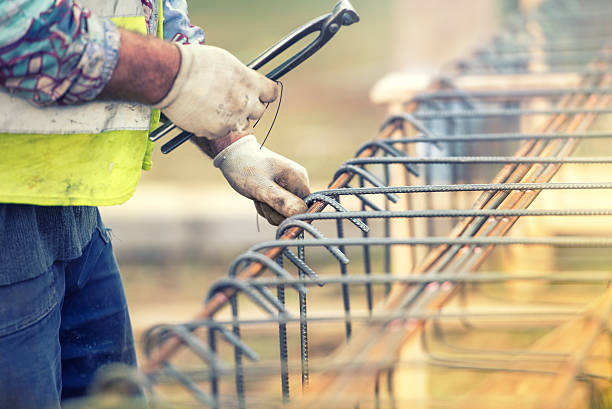 operaio utilizzando inossidabile per fissare bar su luogo di costruzione - formworks foto e immagini stock