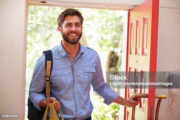 Young Man Returning Home For Work With Shopping Stock Photo - Download Image Now - Arrival, Domestic Life, Men