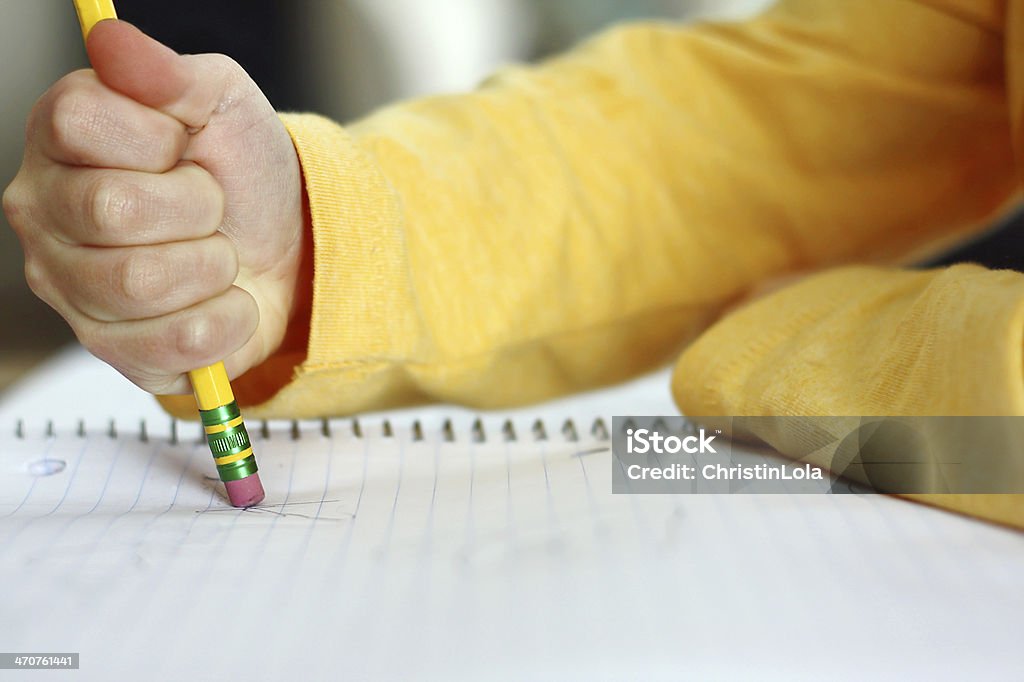 Child's Hand Erasing with Pencil on Notebook Paper a child has made a mistake while writing and is holding a pencil and erasing on white notebook paper Mistake Stock Photo