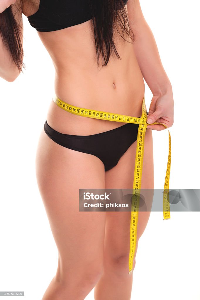Young Woman measuring her waist - Stock Image Weight loss concept - Stock Image 20-29 Years Stock Photo