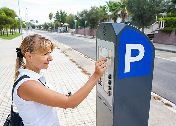 mujer joven pagar para el estacionamiento sin servicio de valet - metal door measuring work tool fotografías e imágenes de stock