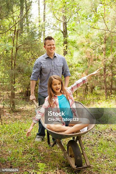 Father Daughter Cleanup Yard Family Garden Outdoors Wheelbarrow Fun Stock Photo - Download Image Now