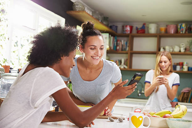 istock Female Friends Making Breakfast Whilst Checking Mobile Phone 470766012
