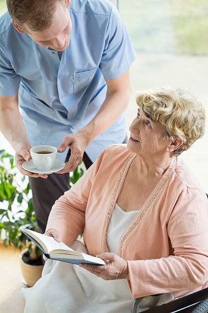 istock Caregiver helping disabled pensioner 470766110