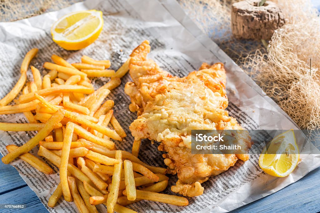 Tasty fish cod with chips served in paper Tasty fish cod with chips served in paper. Fish Stock Photo
