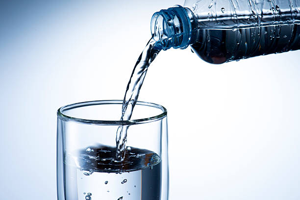 istock Hand holding bottle water and pouring 470770717