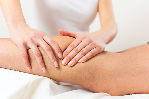 Physical therapist massaging calf stock photo