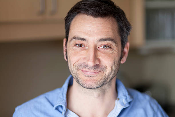 Portrait of a middle-aged man smiling softly indoors stock photo