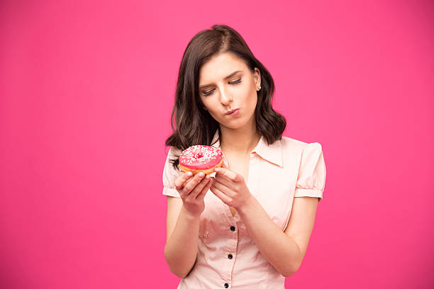 istock Pensive woman holding donut 470778894