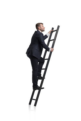 Young businessman is climbing to the career ladder. Isolated.