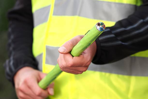 Fiber optic ribbon cable end hand held Melbourne, Australia - April 18, 2015: Green Nylon jacketed 576 fiber optic ribbon cable end used for the National Broadband Network in Australia, a fast internet rollout covering 90% of Australia. broadband isp stock pictures, royalty-free photos & images